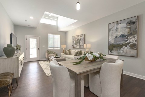 a living room and dining room with white chairs and a table